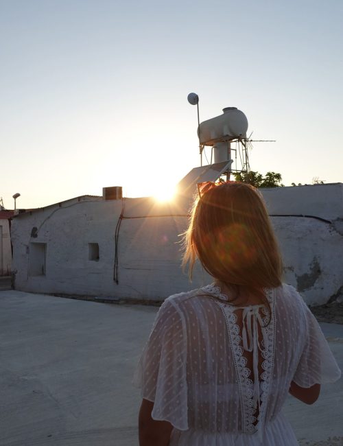 jana-schumacher-im-weißen-kleid-bei-sonnenuntergang-im-rückenprofil